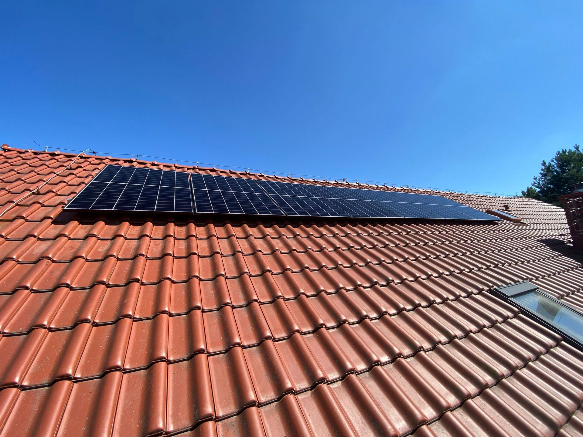 Panel fotowoltaiczny na ceglanym pomarańczowym dachu